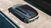 Modern mint-green electric SUV with black roof, sporty wheels, and sleek urban design.