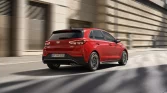Roter Sportkombi fährt dynamisch durch eine moderne Stadt.