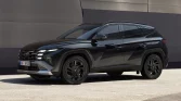 Schwarzer moderner SUV seitlich geparkt vor metallischer Wand in urbaner, minimalistischer Umgebung