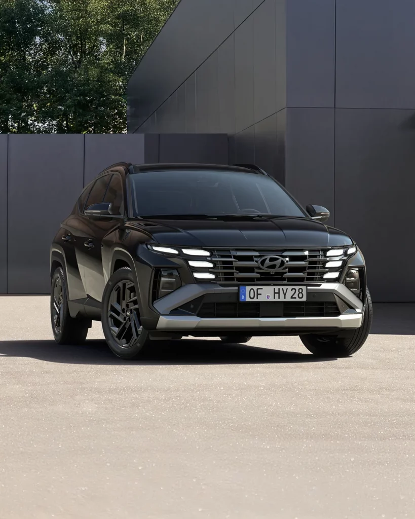 Schwarzer Hyundai SUV frontal vor moderner Fassade mit urbanem Hintergrund und leichtem Schatten