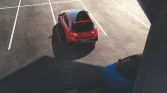 Roter Hyundai Kompaktwagen schräg in fast leerem Parkhaus, aufgenommen aus erhöhter Perspektive bei Tageslicht