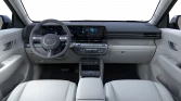 Innenraum eines modernen, hellgrauen Hyundai Elektro-SUV mit digitalem Cockpit und Touchscreen von hinten aufgenommen