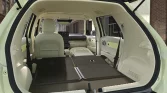 Beige SUV mit umgeklappten Rücksitzen, von hinten im urbanen Umfeld mit offener Heckklappe gezeigt