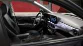 Moderner Innenraum eines kompakten Hyundai mit schwarzem Stoff und roten Akzenten, Blick durch Fahrerseite ins Cockpit