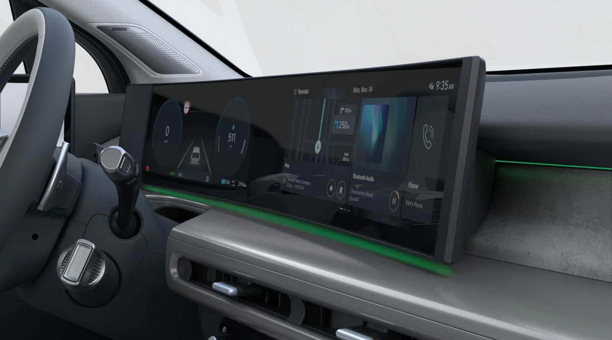 Innenraum eines modernen elektrischen Hyundai SUV mit breitem Digitaldisplay und Ambientebeleuchtung in Grün