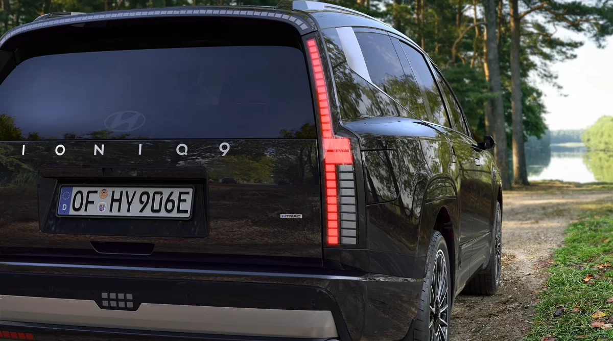Schwarzer Hyundai SUV von hinten in Waldlandschaft mit See im Hintergrund, reflektierende Karosserie