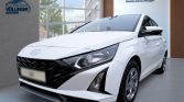 Weiße Hyundai Limousine seitlich-vorne im hellen Autohaus mit „Hyundai Promise“ Zertifikat im Hintergrund