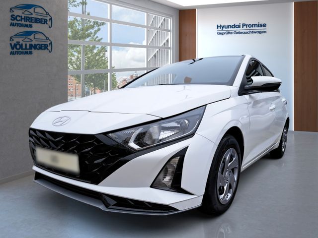 Weiße Hyundai Limousine seitlich-vorne im hellen Autohaus mit „Hyundai Promise“ Zertifikat im Hintergrund