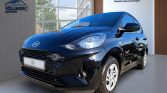 Schwarzer Hyundai Kleinwagen im Showroom frontal-dreiviertel Perspektive vor heller Glasfassade