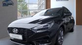 Schwarzer Hyundai Limousine seitlich im hellen Autohaus mit Markenlogos und Fensterfront positioniert
