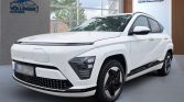 Weißer Hyundai SUV seitlich im hellen Showroom mit moderner Einrichtung und großen Fenstern