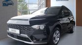 Schwarzer Hyundai Kompakt-SUV seitlich im hellen Autohaus mit großen Fenstern und grüner Außenkulisse