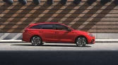 Roter Hyundai Kompaktwagen seitlich geparkt vor urbaner Backsteinmauer mit Schattenspiel