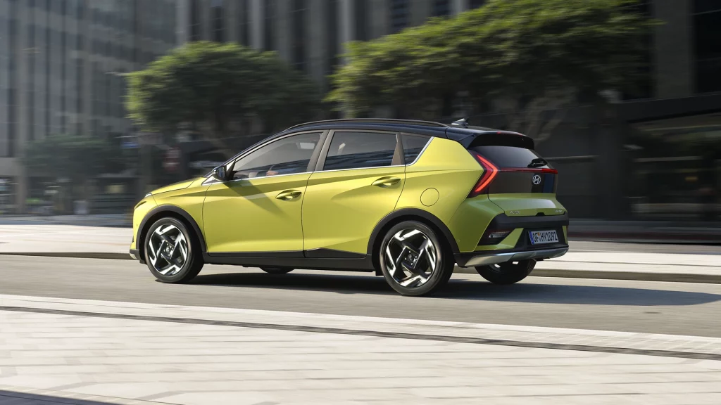 Hyundai Kompakt‑SUV limettengrün, Seitenansicht in urbaner Umgebung, fahrend