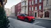 Mattroter Hyundai Crossover seitlich geparkt vor klassischer Stadthausfassade