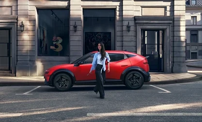 Roter Hyundai SUV seitlich geparkt vor urbanen Gebäuden, Person geht vorbei