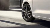 Perlweißer Hyundai Kompaktwagen, Nahaufnahme des Rads aus niedriger Perspektive auf hellem Pflaster